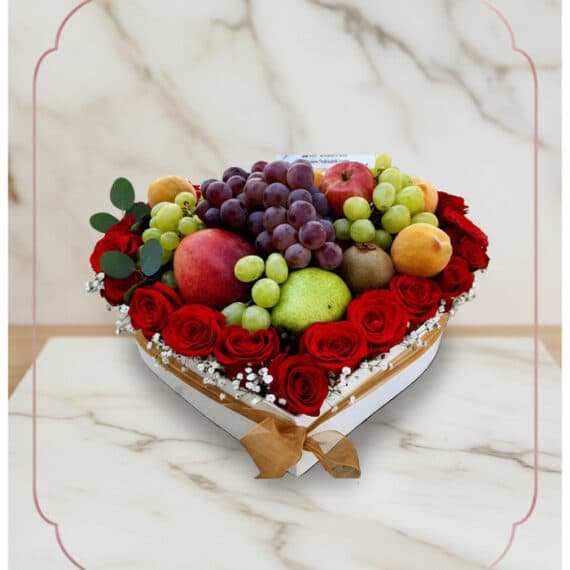ARMANI: Arreglo Exquisito de Frutas y Rosas Rojas en Corazón Arreglo floral ARMANI con frutas frescas variadas y rosas rojas dispuestas en una caja blanca en forma de corazón, ideal para