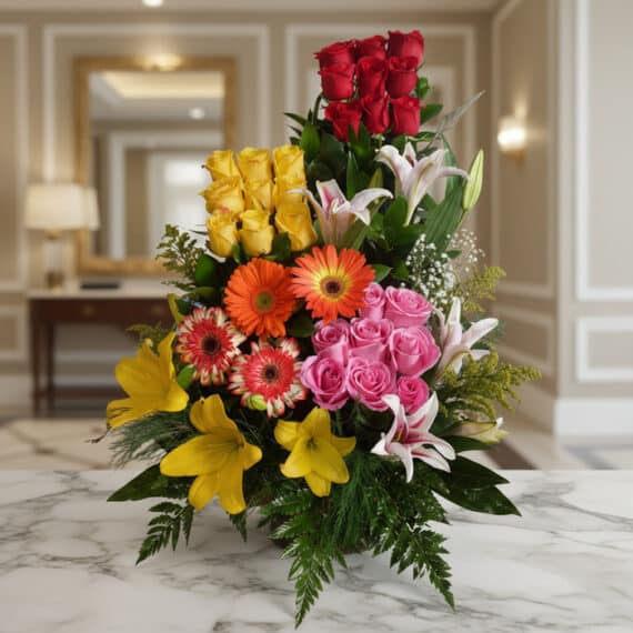 Arreglo Floral Exótico Paraíso: Lirios, Rosas y Gerberas en Entorno Elegante Arreglo floral exótico Paraíso con rosas rojas, amarillas y rosadas, lirios blancos y amarillos, y gerberas naranjas y rojas,