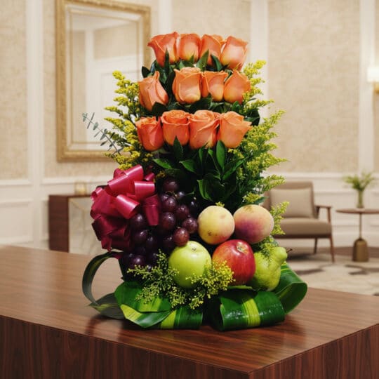 Arreglo floral premium con rosas salmón, uvas, manzanas, duraznos y peras, sobre una mesa de madera pulida en un lobby de hot
