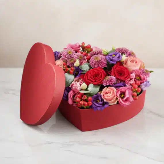Arreglo Floral ZITA: Caja Corazón con Rosas y Flores Mixtas 💝 Arreglo floral ZITA en caja de corazón roja con rosas rojas, rosadas y flores mixtas, ideal para regalar en ocasiones especia
