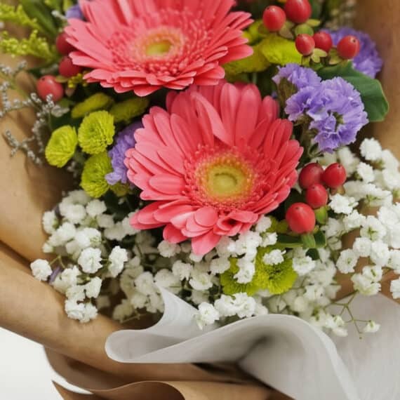 Primer plano extremo de un vibrante Bouquet Floral LIA con gerberas amarillas, gotas de rocío y textura hiperrealista, envuel