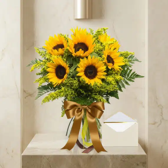 Bouquet de Girasoles LAIA con 10 flores frescas, cinta satinada dorada y tarjeta de regalo elegante sobre mármol pulido.
