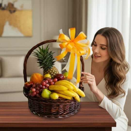 Mujer joven y elegante admirando una canasta de frutas Sirio con piña, uvas, plátanos y otras frutas frescas, decorada con un
