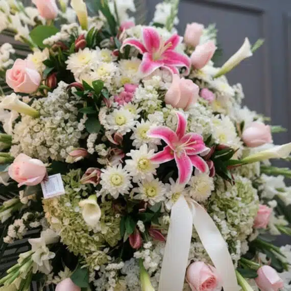 Fotografía macro premium del Pedestal Fúnebre Pasión, mostrando texturas hiperrealistas de rosas, lirios y follaje con rocío