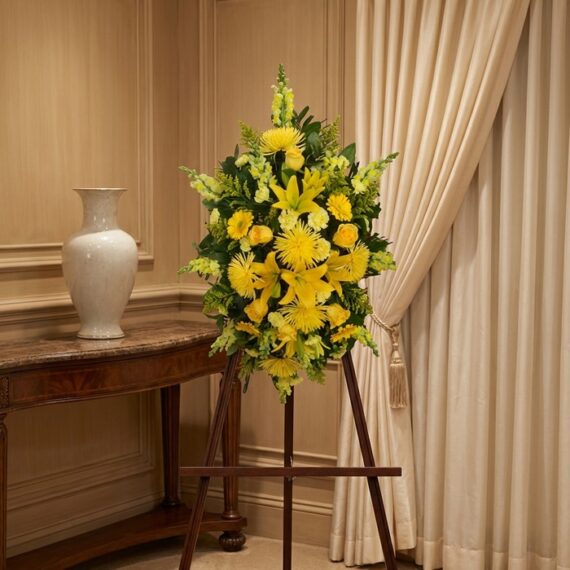Pedestal de Homenaje «El Legado de Sebastian» con Flores Amarillas Pedestal de homenaje "El Legado de Sebastian" con un arreglo floral fúnebre de lirios y crisantemos amarillos, presentado ele