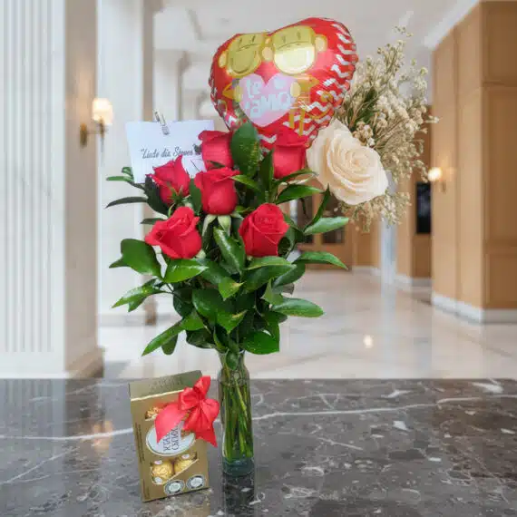 Arreglo floral Solitario con Rosas Me Enamoras, rosas rojas y una rosa blanca, follaje verde, globo de corazón 'Te Amo' y caj